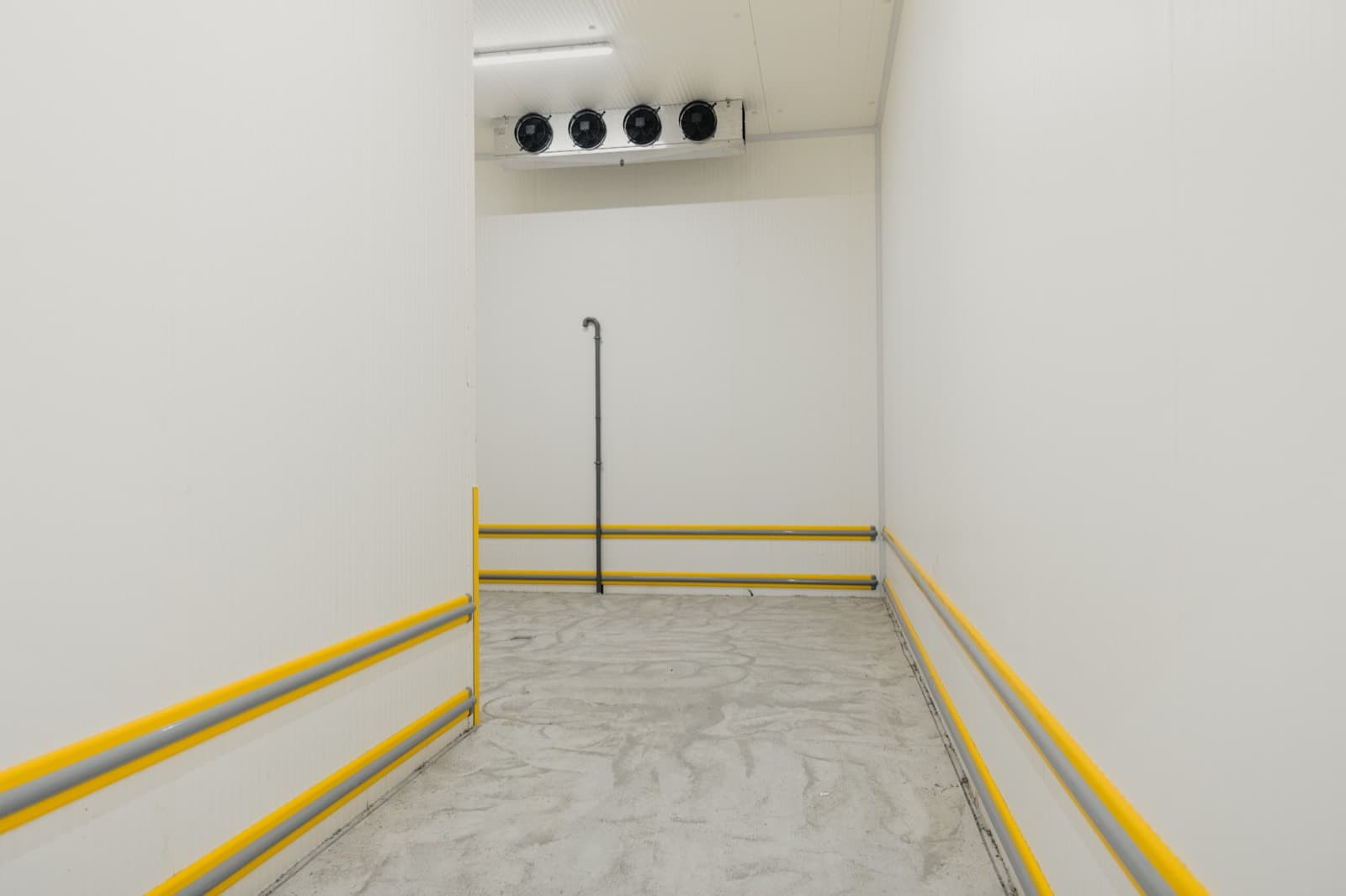 The interior of a commercial walk-in cooler with a ceiling-mounted evaporator unit.